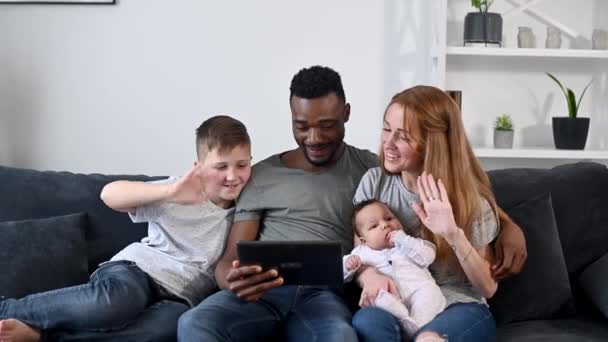 En lycklig multiracial familj på fyra med en tablett — Stockvideo