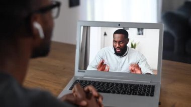 Video görüşmesi için laptop kullanan Afrikalı bir adam.