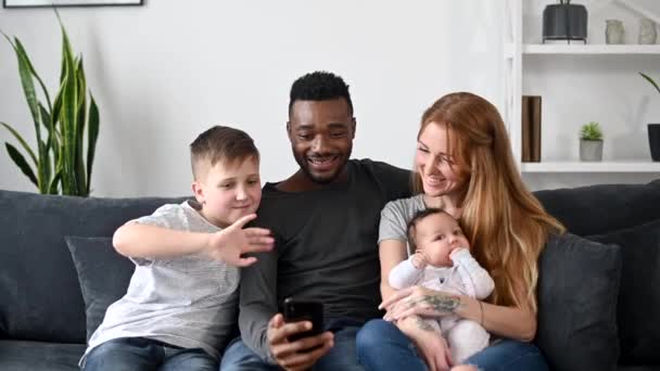 Een multiraciale familie van vier heeft een videogesprek. — Stockvideo