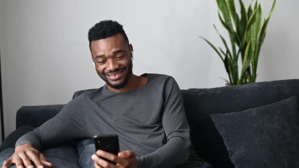 Un ragazzo afro-americano con uno smartphone a casa — Video Stock