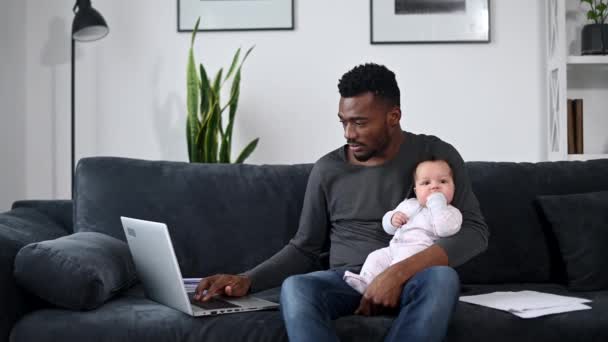 Egy apa otthonról dolgozik. — Stock videók