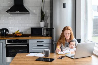 Uzaktan kumanda için dizüstü bilgisayar kullanan genç bir anne.