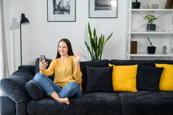 Chica joven con un teléfono inteligente, habla en línea — Foto de Stock