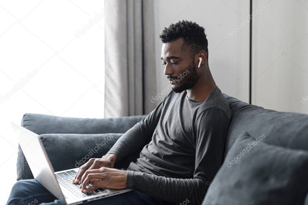 An African-American guy with a laptop at home