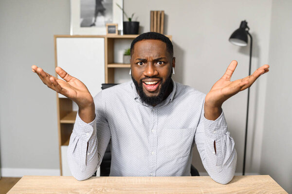 Frustrated African American worker raising hands up