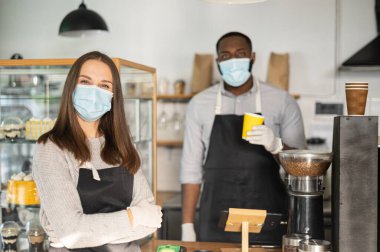 Bir garson ve tıbbi maskeli bir garson.