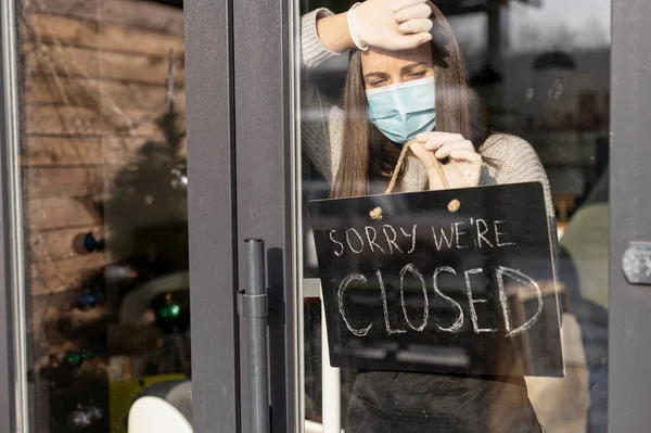 A waitress in a medical mask with closed sign — Stock Photo, Image