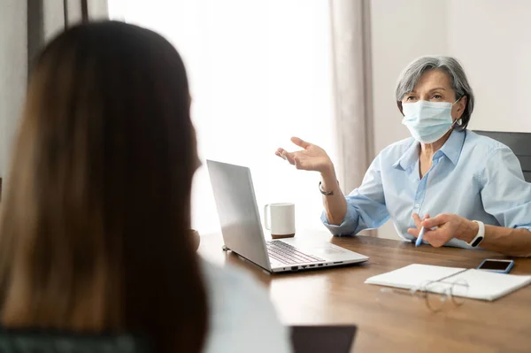 戴口罩的老年女经理面试 — 图库照片