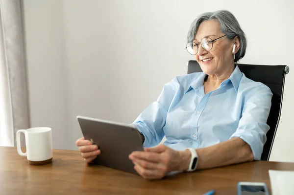 Krásná okouzlující senior businesswoman pomocí tabletu — Stock fotografie