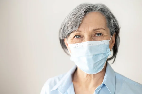 Middle aged female businesswoman in a face mask — Stock Photo, Image