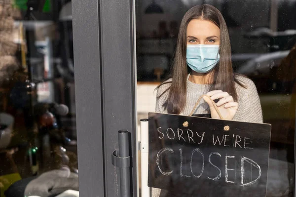 A waitress in a medical mask with closed sign — Stock Photo, Image