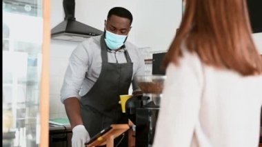 Tıbbi maskeli Afrikalı bir garson.