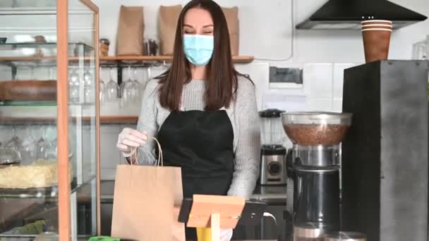 Een serveerster met een beschermend medisch masker — Stockvideo