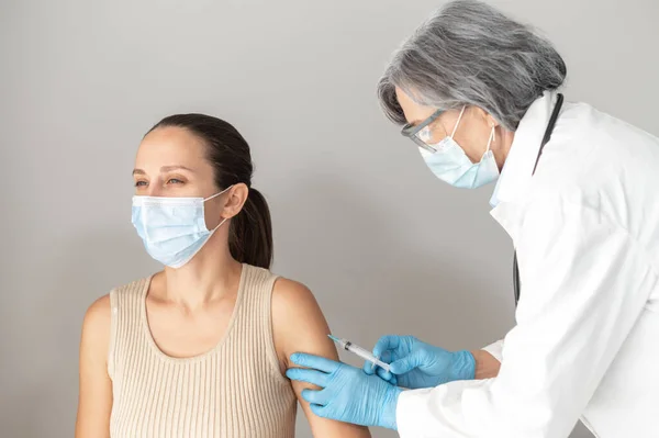 A jovem está a receber uma vacina contra o covid-19. — Fotografia de Stock