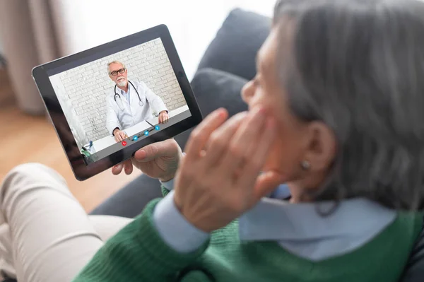 Старша леді розмовляє з лікарем онлайн — стокове фото