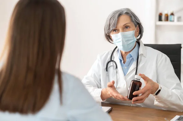 Médica sênior conversando com seu paciente — Fotografia de Stock