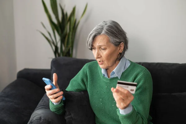 Здивована старша леді робить платіж онлайн — стокове фото