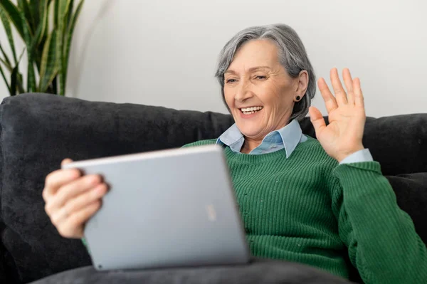 Mature lady is talking online on the touchpad
