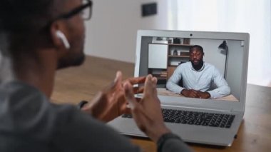 Video görüşmesi için laptop kullanan Afrikalı bir adam.