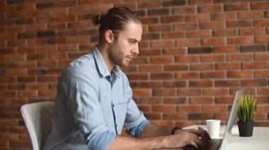 İçerde dizüstü bilgisayarı olan bir adam.