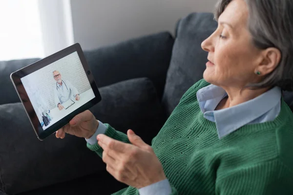 Старша леді розмовляє з лікарем на веб-камеру — стокове фото