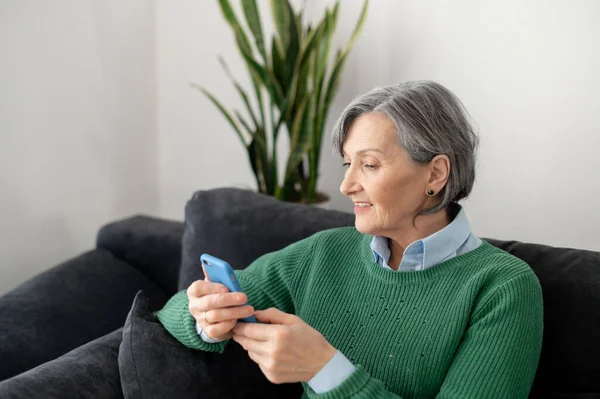 Senior lady instaluje aplikaci pro mobilní telefon — Stock fotografie