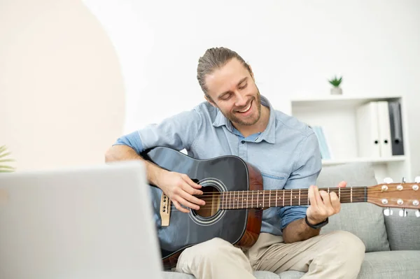 Attraente hipster gioioso suonare la chitarra online — Foto Stock