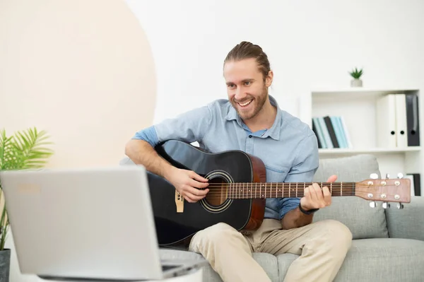 Attraente hipster gioioso suonare la chitarra online — Foto Stock