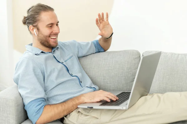 Hipster man is waving at the laptop screen — Stock Photo, Image