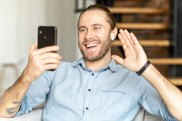 Smiling hipster man waving at mobile phone — ストック写真