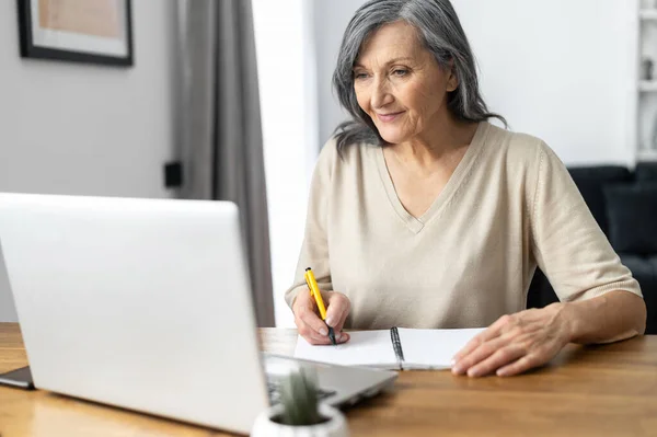 Сучасна старша жінка використовує ноутбук — стокове фото