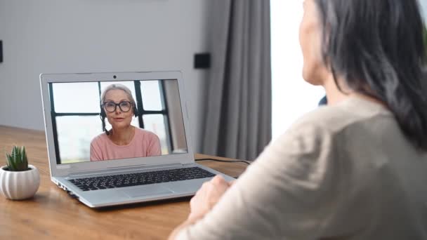 Женщина средних лет использует ноутбук для видеозвонков — стоковое видео