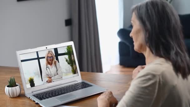 Mujer de mediana edad utilizando el ordenador portátil para videollamada — Vídeos de Stock