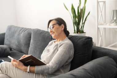 Evde olgun yaşlı bir kadın var.