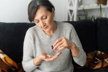 Yaşlı bir kadın kendini hasta hissediyor.