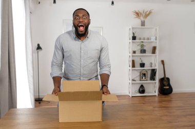 Adamın biri evde bir paket kutusu açıyor.