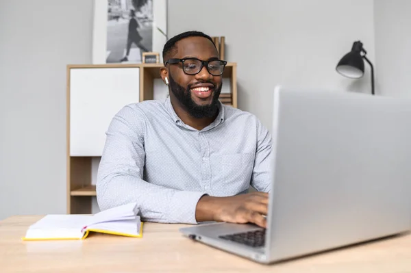 Hombre de negocios afroamericano escribiendo en una computadora portátil — Foto de Stock