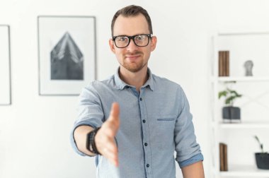 Bir adam elini uzattı ve el sıkışma hareketi yaptı.