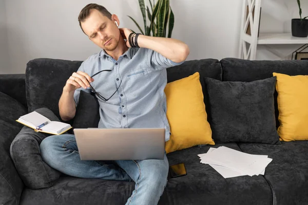 Уставший бизнесмен с ноутбуком на диване — стоковое фото