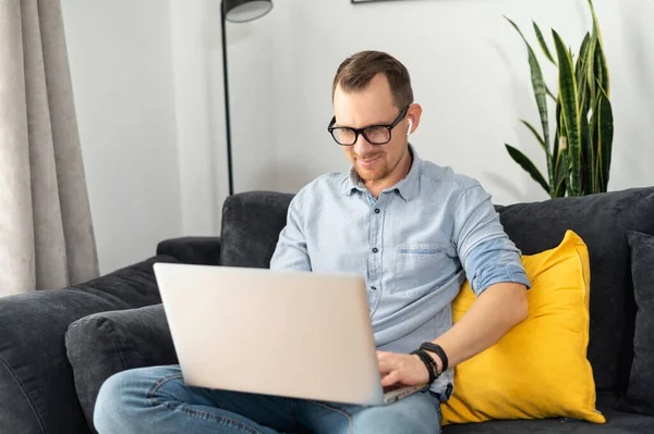 Um cara freelancer está usando laptop em casa — Fotografia de Stock