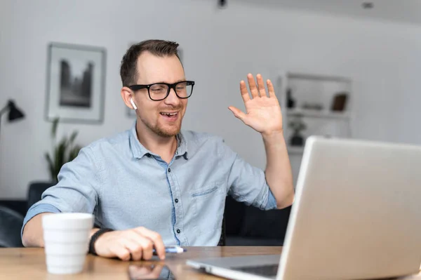 A guy is using laptop sitting at the desk