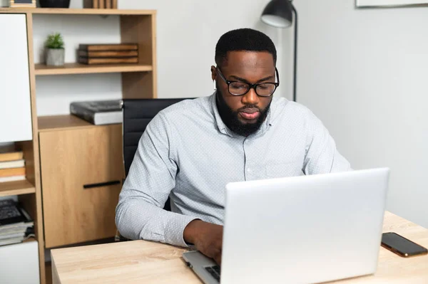 Trabalhador afro-americano do sexo masculino digitando em um laptop — Fotografia de Stock