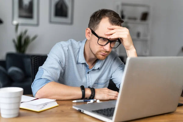 Un tipo está usando un portátil sentado en el escritorio —  Fotos de Stock