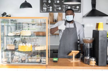 Tıbbi maskeli Afrikalı bir garson.