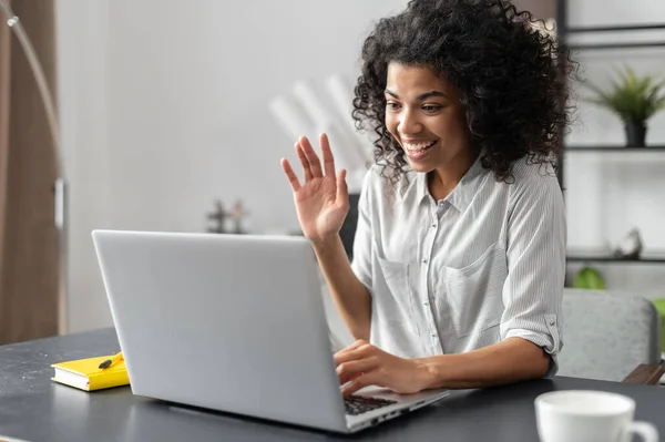 African American woman waving at the laptop screen — Stock Photo, Image