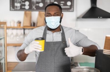 Tıbbi maskeli Afrikalı bir garson.