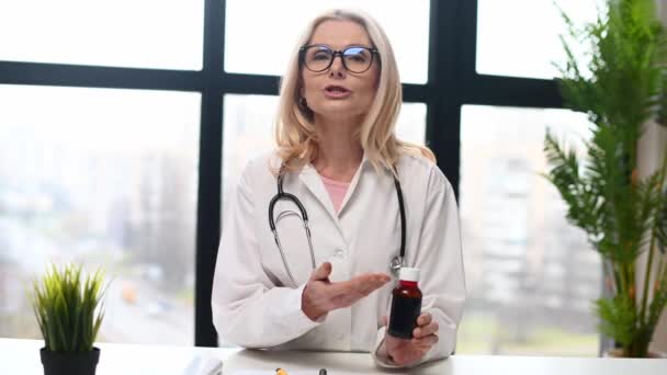Уверенный терапевт держит в руках бутылку лекарства — стоковое видео
