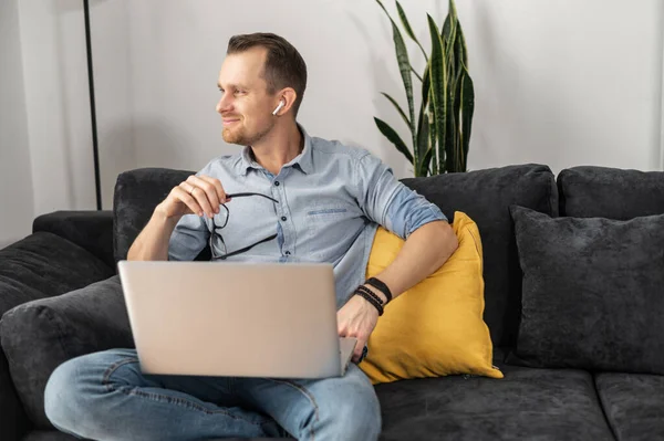 Um cara freelancer está usando laptop em casa — Fotografia de Stock