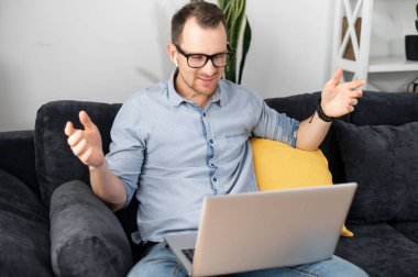 Bir iş adamı video görüşmesi için laptop kullanıyor.