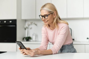 Akıllı telefonlu çekici orta yaşlı kadın.